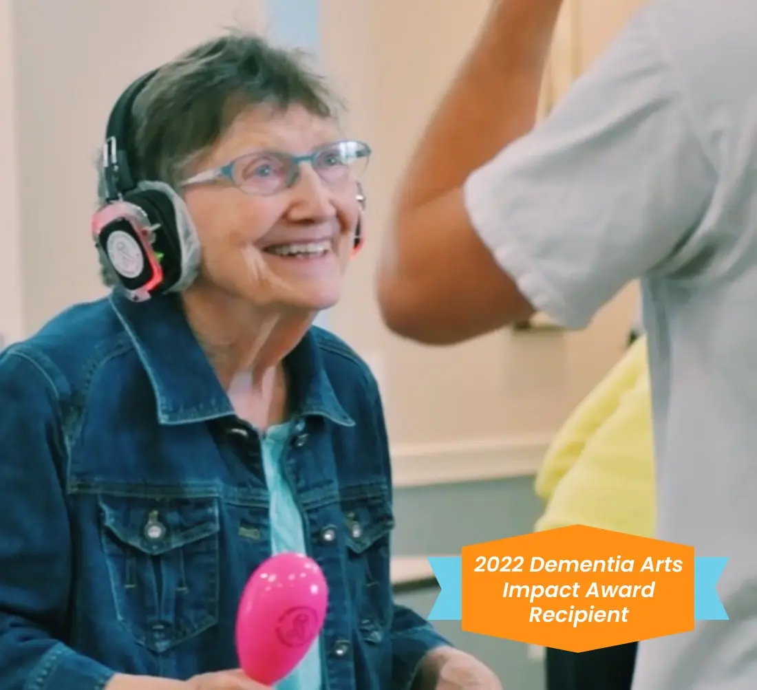 Woman dancing with headphones on and playing musical instrument