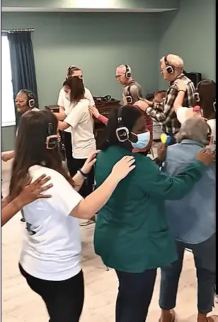 Group of people with headphones on dancing in a room