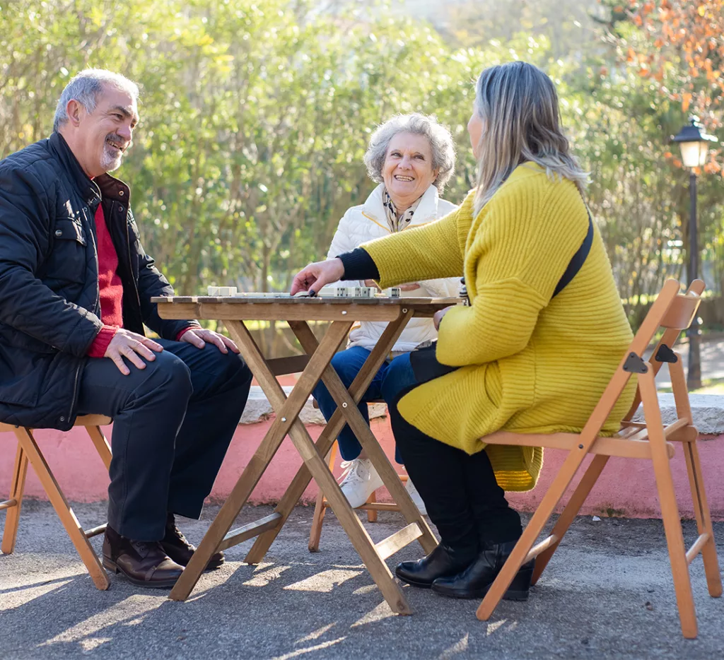 Older man and woman sitting outdoors with younger woman