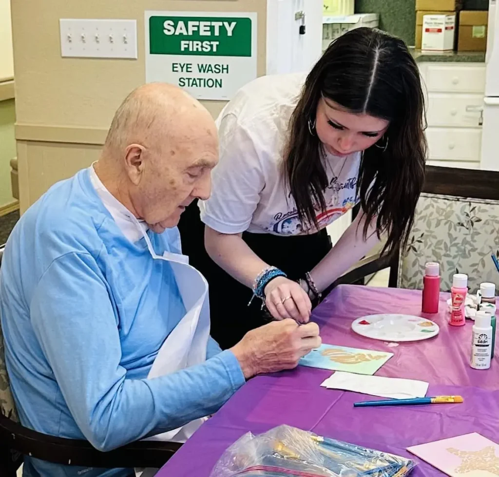 Roselyn with resident helping to paint