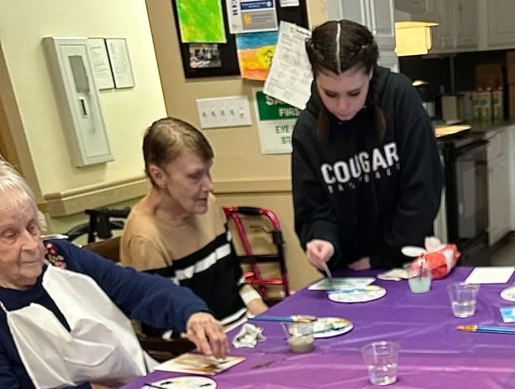 Roselyn with resident helping to paint