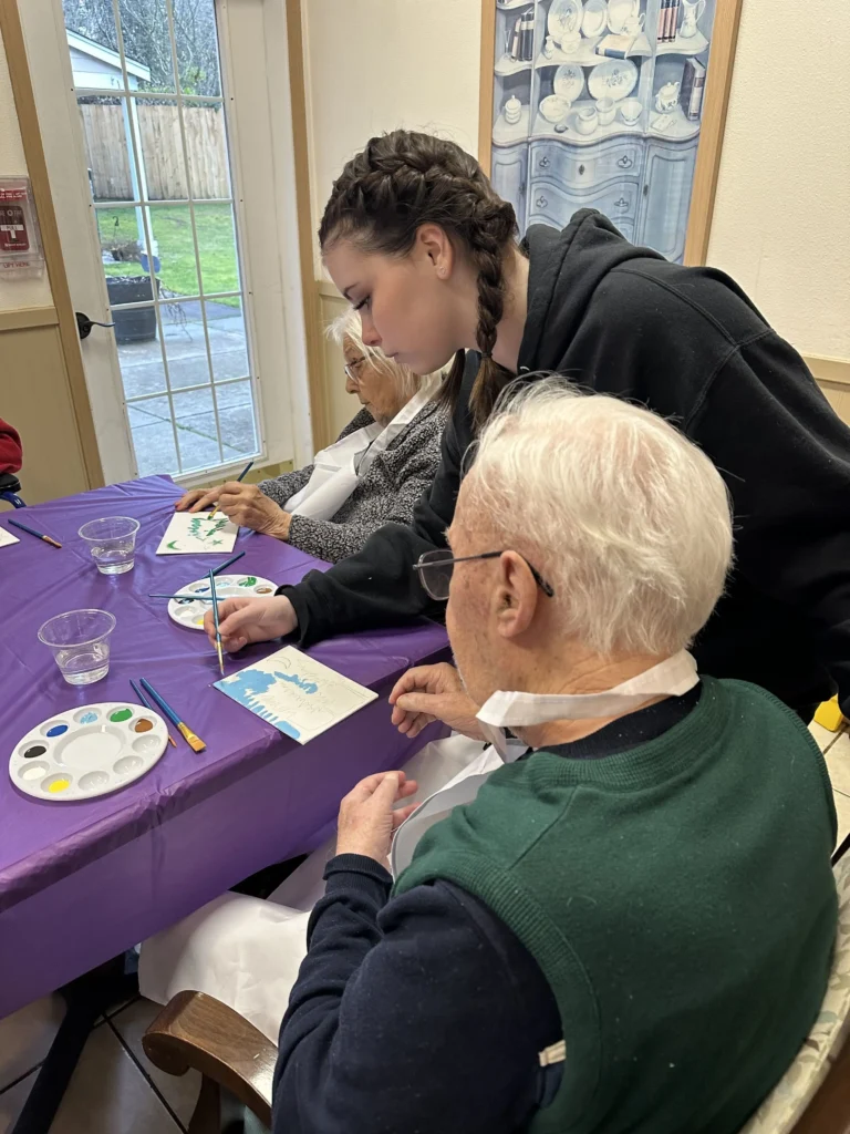 Roselyn with multiple residents helping to paint