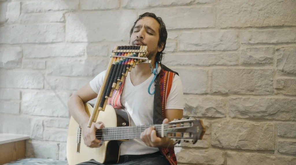 Vladimir Garrido-Biagetti, director of the Spanish-speaking Centro chorus, plays the guitar.