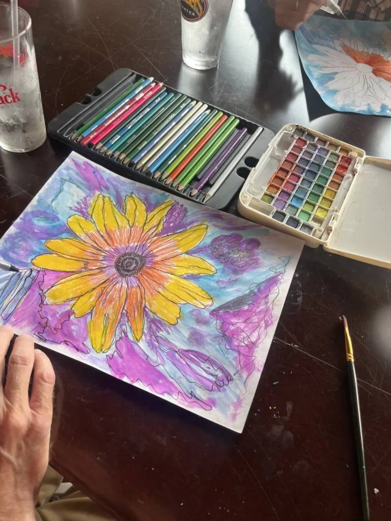 Person coloring a flower