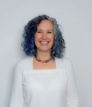 Headshot of Kelly de la Rocha smiling brightly.