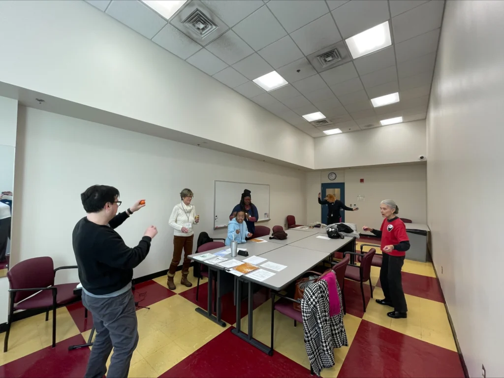 A group of people are participating in an activity involving singing instruction