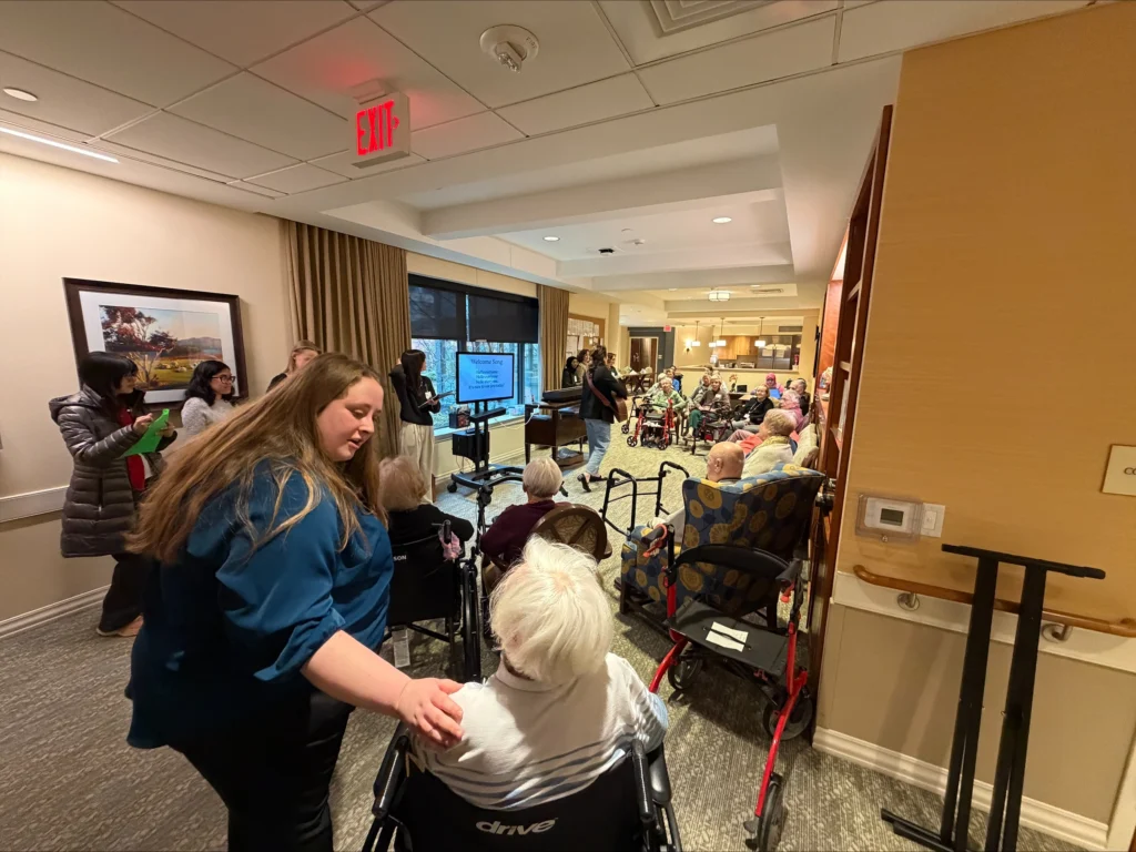 A group of elderly people are led in song