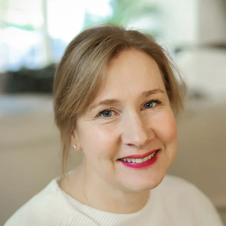 michelle with red lipstick, blonde hair, and a white shirt