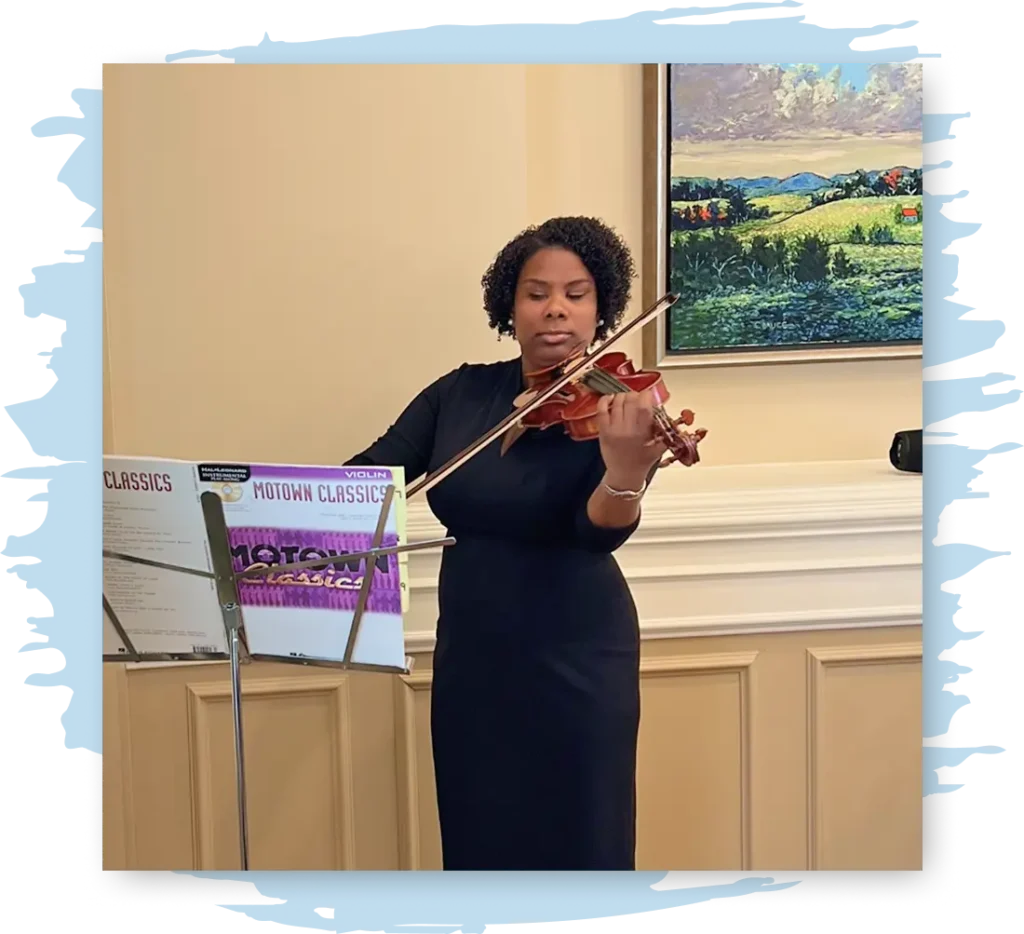Melanie stands before a music stand playing the violin