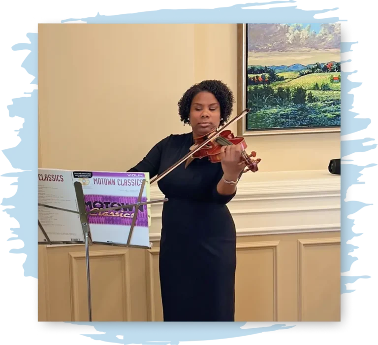 Melanie stands before a music stand playing the violin