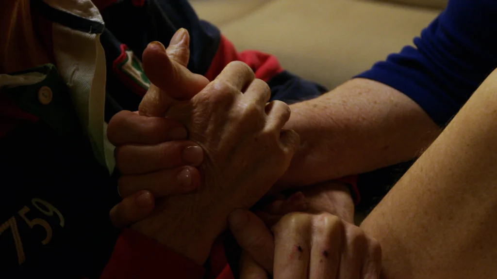 A close up image of two people clasping hands